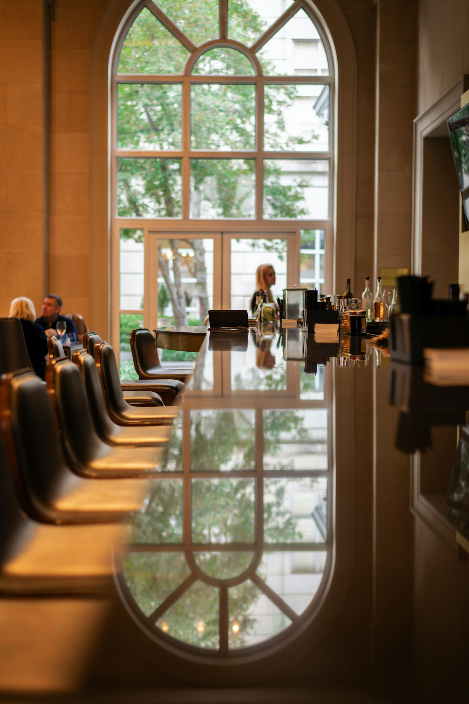 A long, empty meeting table lined with chairs in front of a large window.