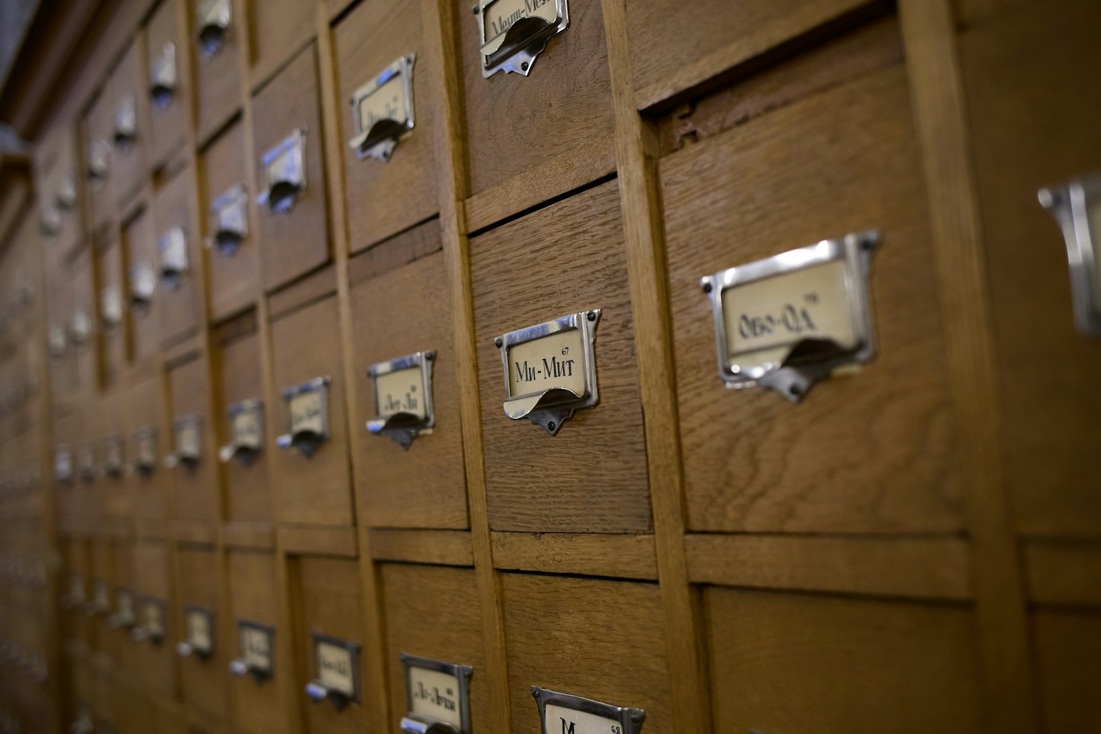 Rows of wooden card catalog drawers, each with a small metal label holder.